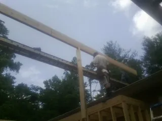 Carpenter setting a ridge beam over a new addition frame — Ice Dam Removal by Roofing Brothers in Fort Lee